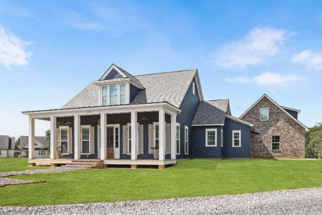 Acadian Farmhouse Exterior – Blending Classic Acadian and Southern Farmhouse Styles Acadian Farmhouse with gabled roof, deep front porch, and mixed brick and board-and-batten siding