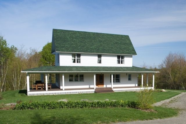 Traditional Farmhouse Exterior – Symmetrical Design with Southern Porch Charm Traditional Farmhouse with gabled roof, full front porch, and classic horizontal siding
