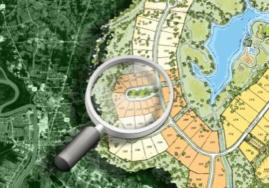 Magnifying glass over a blended map showing satellite imagery and a planned subdivision layout, representing land selection for a custom home