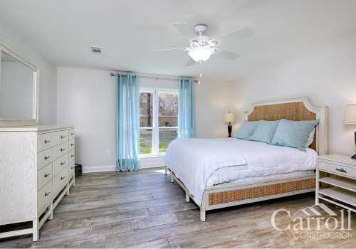 A large master bedroom with custom drapes and flooring
