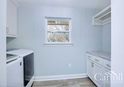 A modern laundry room with counter space and custom cabinets