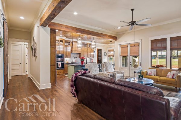great room featuring custom beam work and stained oak cabinetry