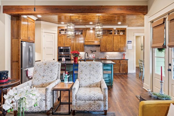 view into kitchen from great room featuring stained oak cabinets and pine ceilings.