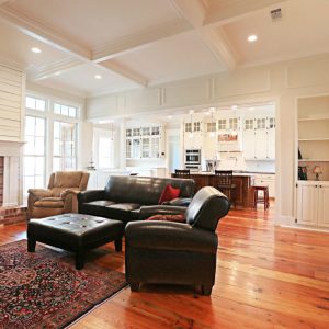 Customized Liberty Plan – Living room with coffered ceiling, nickel gap fireplace, built-ins, and transom windows