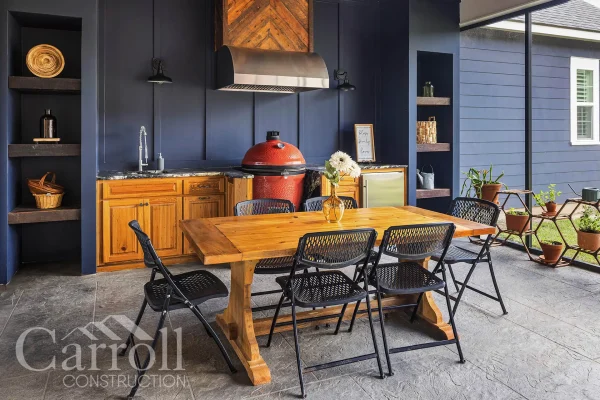 Outdoor kitchen with blue siding, antique cypress cabinets, Blaze vent hood, and reclaimed pine accents