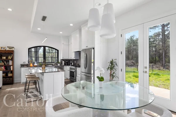 Breakfast area with double full-view doors and kitchen visible in the background