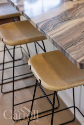 Close-up of leather seat stools tucked under granite island overhang