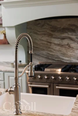Commercial-style kitchen faucet on island with THOR range visible in background
