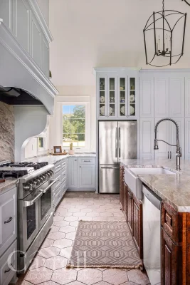 Side view of farmhouse kitchen with glass-front cabinet doors above refrigerator