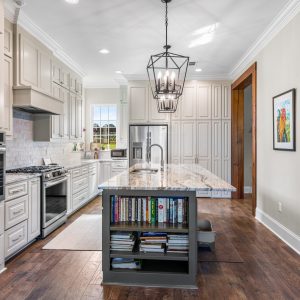 Dittmar Home – Liberty plan, 2,574 SF – kitchen with hidden walk-in pantry wall, floor-to-ceiling cabinets, and island bookshelf.