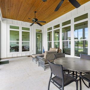 Dittmar Home – Liberty plan, 2,574 SF – porch with stained wood v-groove ceiling facing wall of windows for natural light.